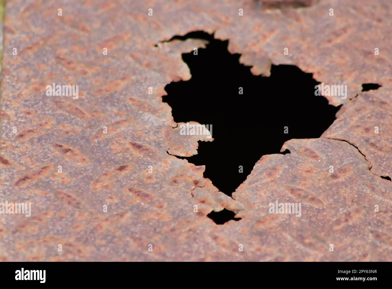 Rostige Metallplatte mit Korrosionslöchern auf alter korrodierter diamantplatte zeigt bei Dampf-Punk-Szenarien mit beschädigter Oberfläche bei Stahlplatten der Kategorie Industrie Grunge-Stahl und verwitterten Metallrost Stockfoto