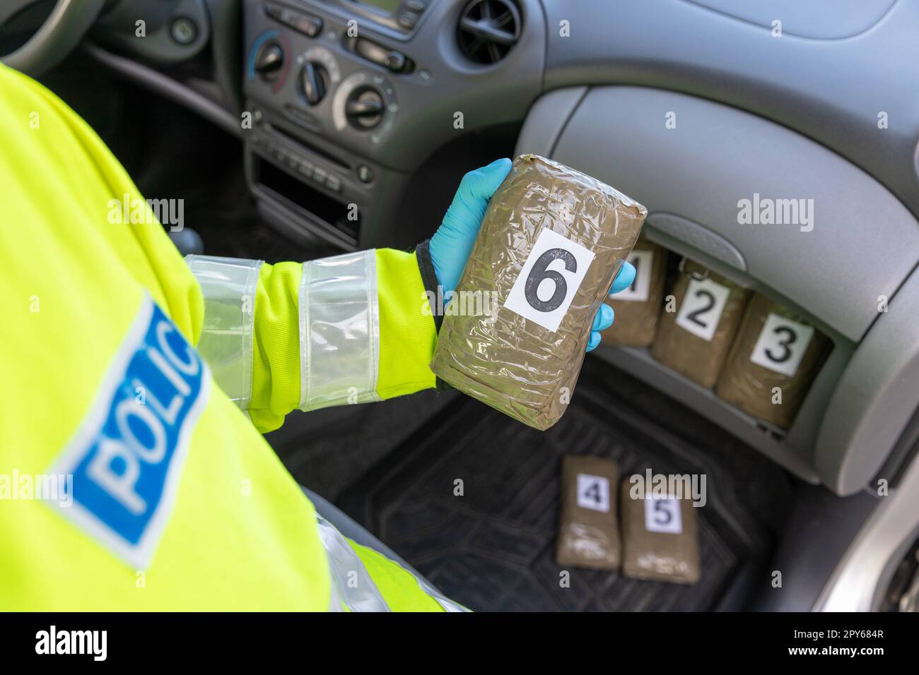 Die Polizei beschlagnahmt Drogen in einem Autoversteck während einer Verkehrskontrolle Stockfoto