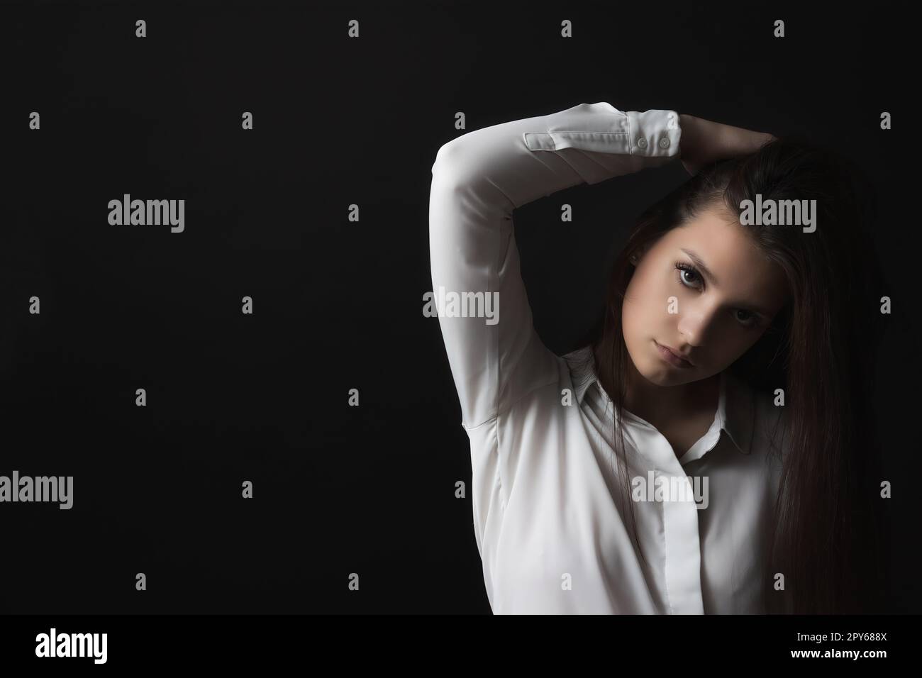 Trauriges Mädchen posiert auf schwarzem Hintergrund. Stockfoto