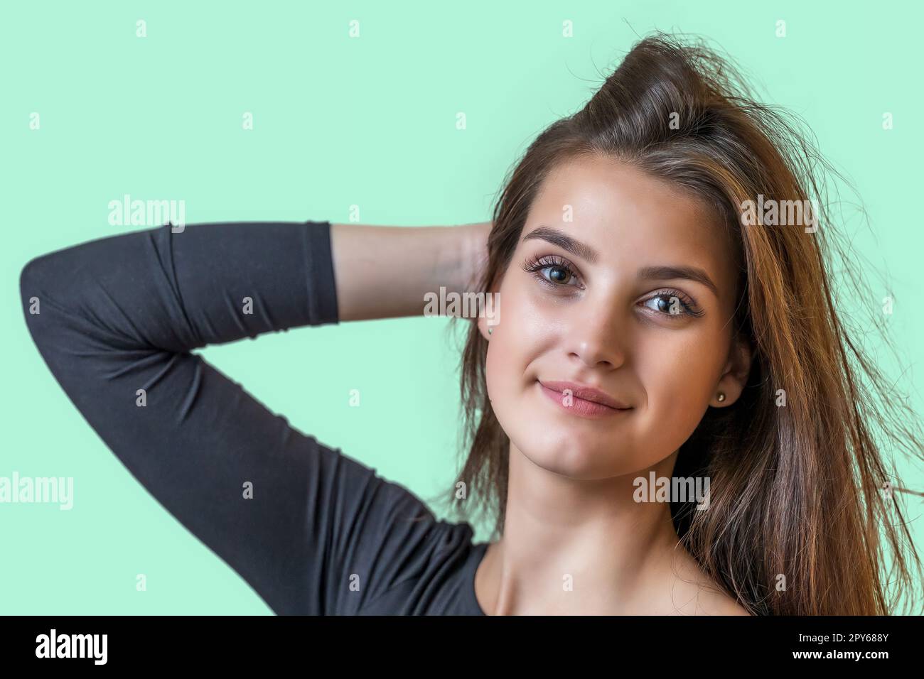 Porträt eines lächelnden, attraktiven Mädchens auf grünem Hintergrund. Stockfoto
