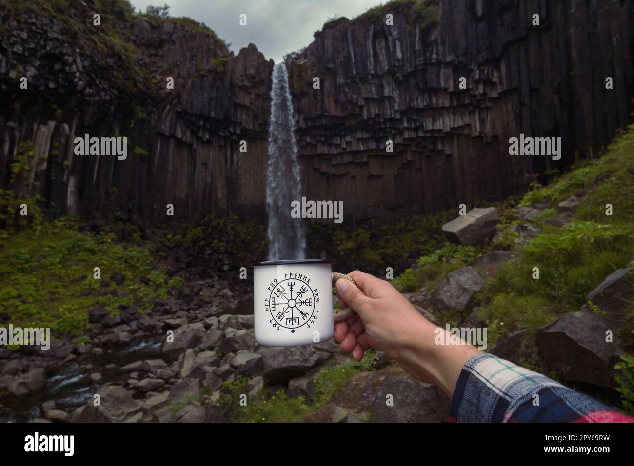 Nahaufnahme männliche Hand imitiert Tassenfüllung nahe Wasserfall Konzeptfoto Stockfoto