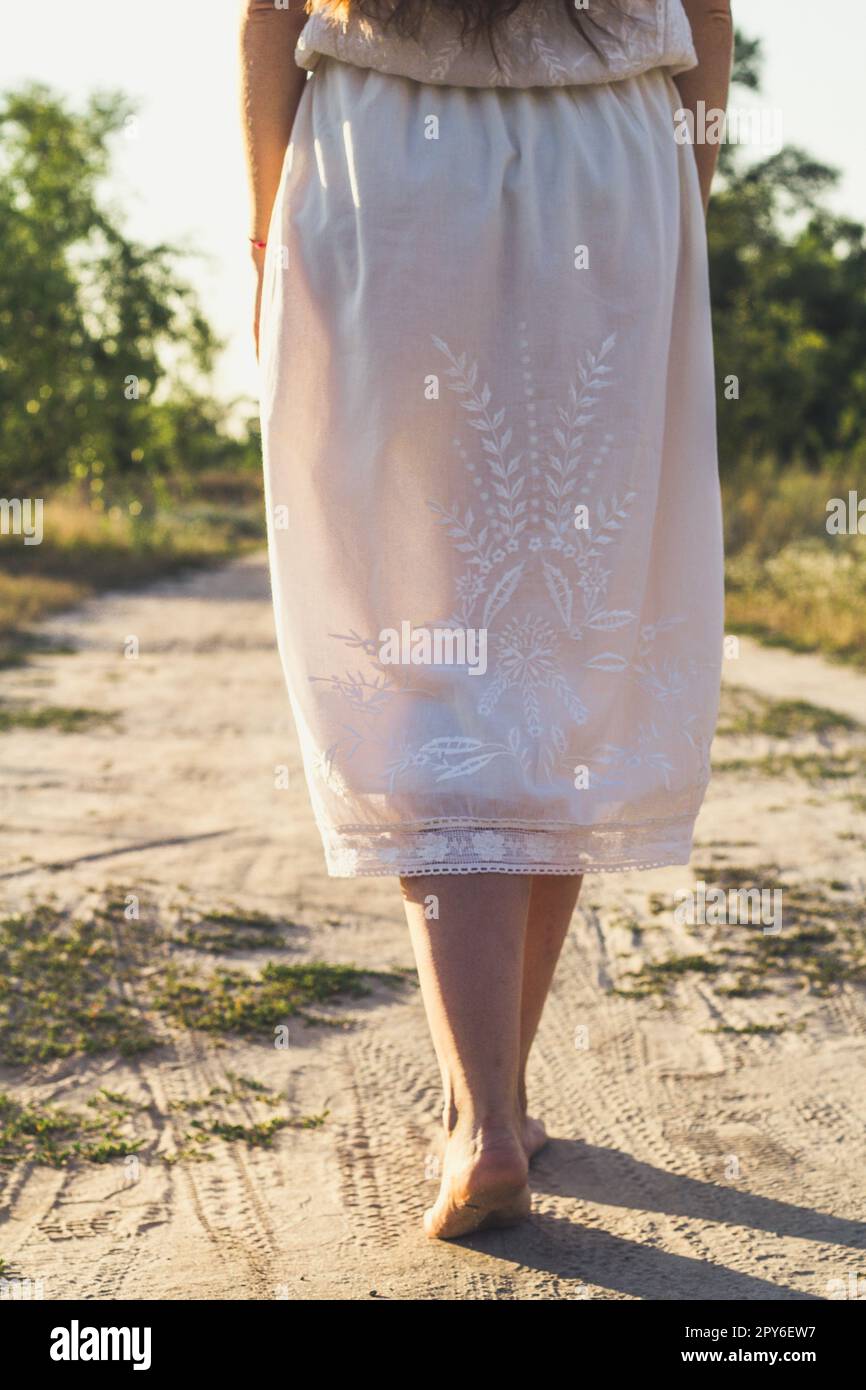 Nahaufnahme einer barfuß Frau, die auf einer Sandstraße läuft, Konzeptfoto Stockfoto