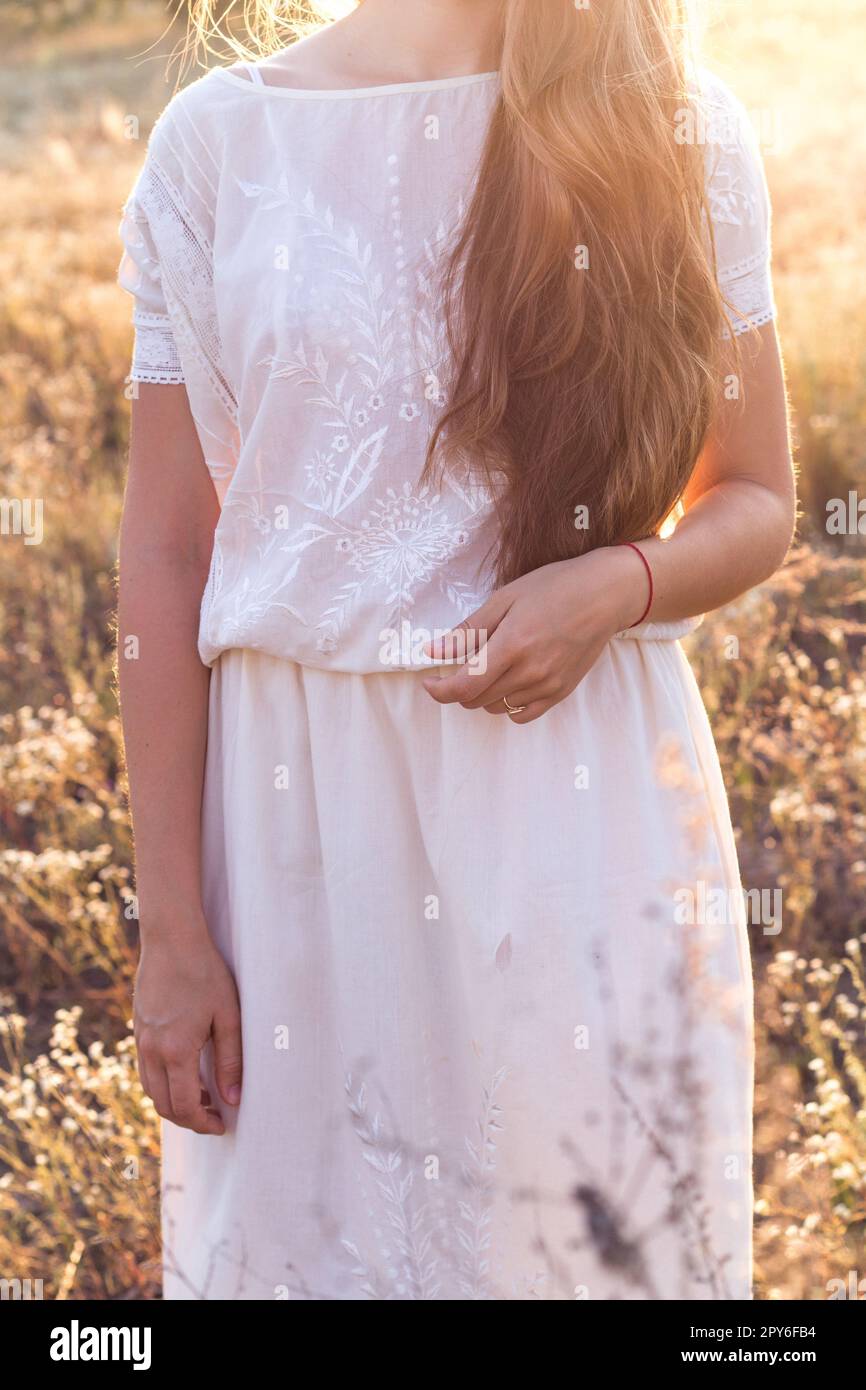 Nahaufnahme Sommermädchen in weißem Leinenkleid mit Rüschen auf der Wiese Konzeptfoto Stockfoto