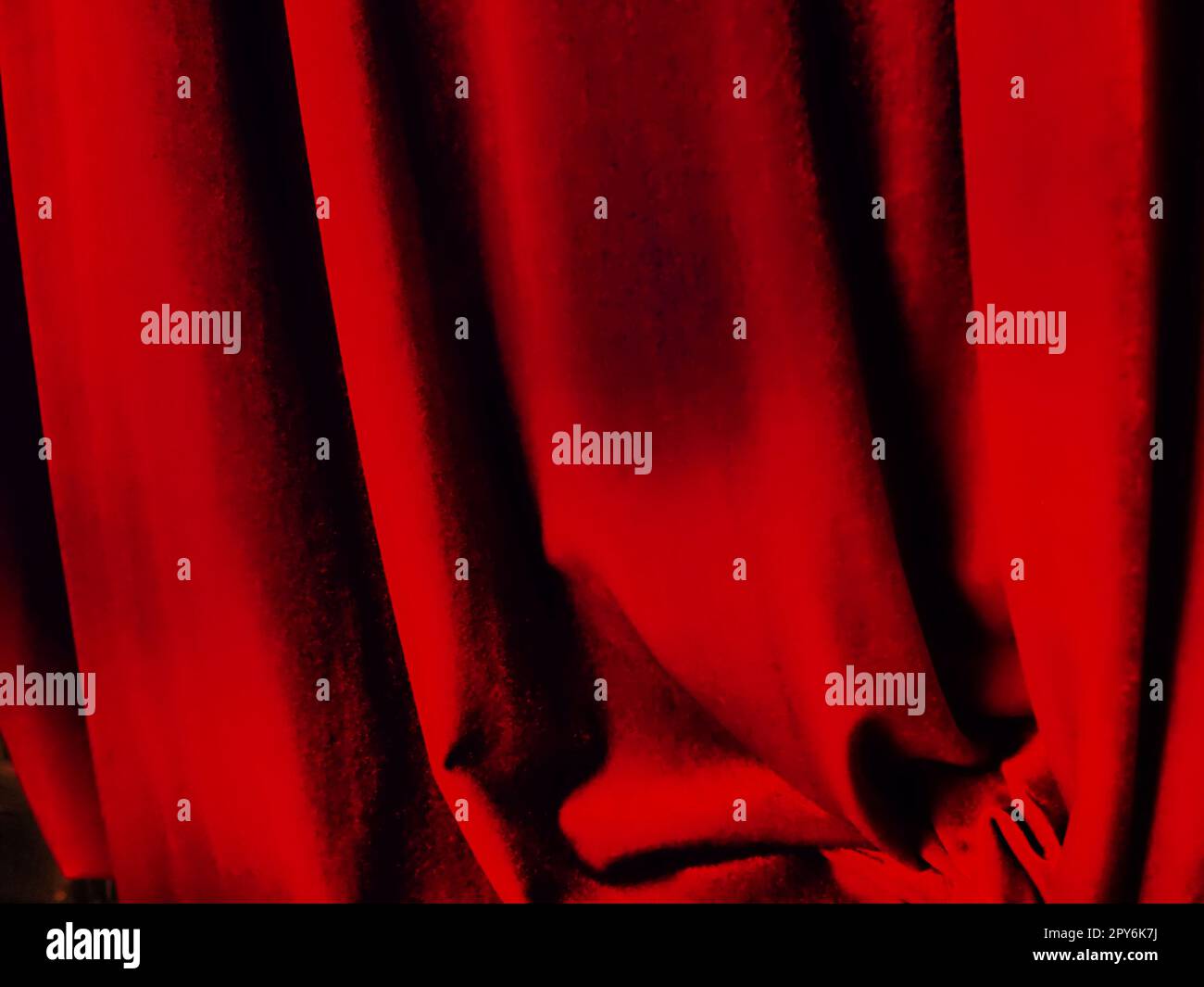 Hellroter abstrakter Hintergrund, der an Falten aus angenehmem Samt erinnert. Stilisiertes unscharfes Bild. Hintergrund für Neujahr, Weihnachten und Valentinstag Stockfoto