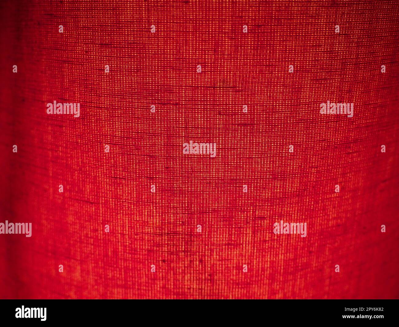 Roter abstrakter Hintergrund aus Stoff. Makrobild. Weben von hahnfarbenen Gruben mit schwarzen Schatten und Vignetten. Hintergrund für Weihnachten, Neujahr, Valentinstag Stockfoto