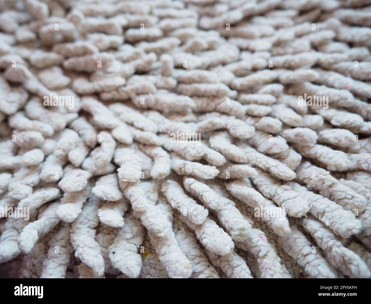 Nahaufnahme eines langen Haufens auf dem Teppich in Beige oder Grau. Rutschfeste Badvorleger oder Toilette. Langer Teppich. Zecken in Teppichen Stockfoto