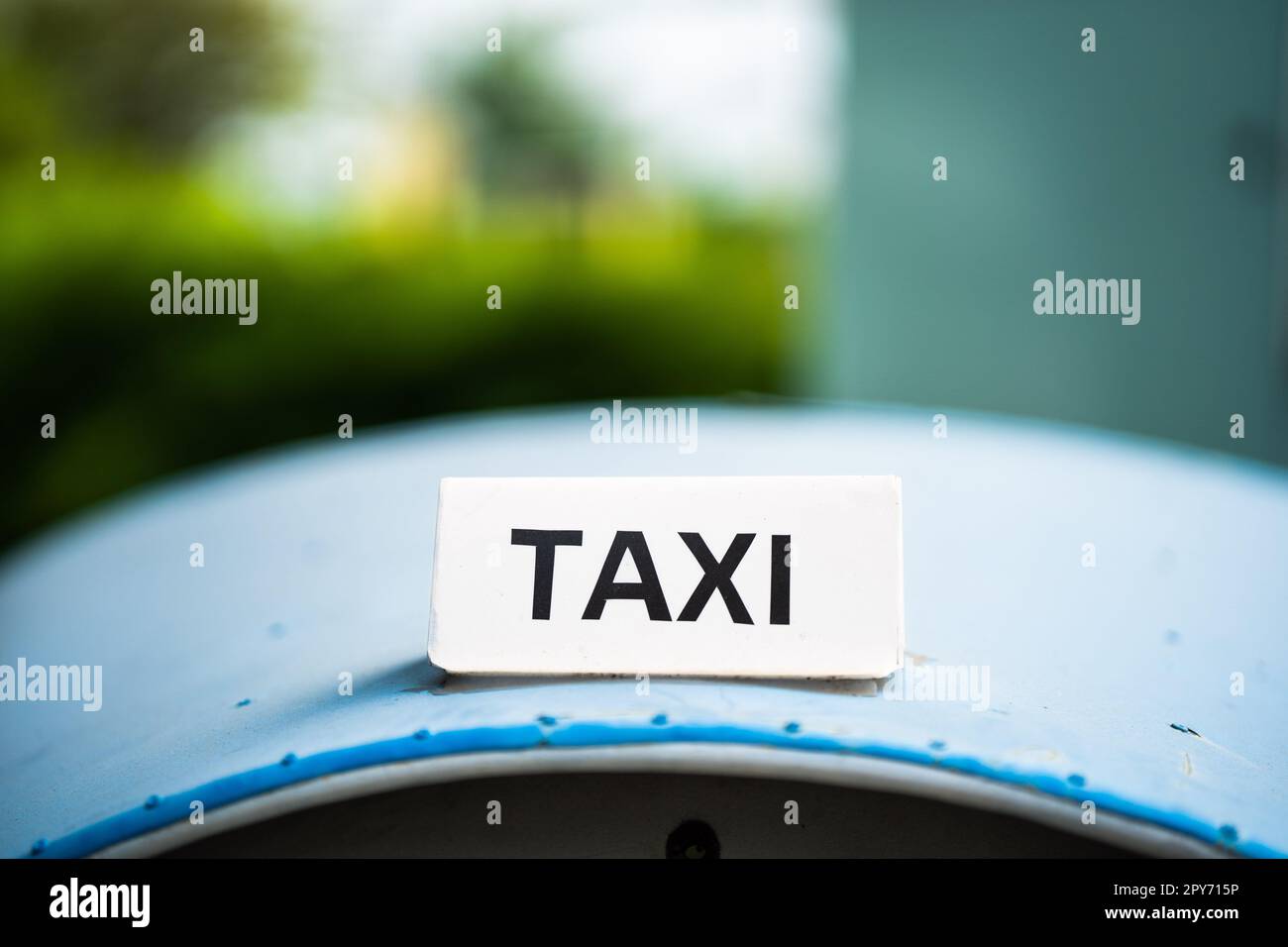 Weißes Taxi-Schild auf blauem Autodach. Stockfoto