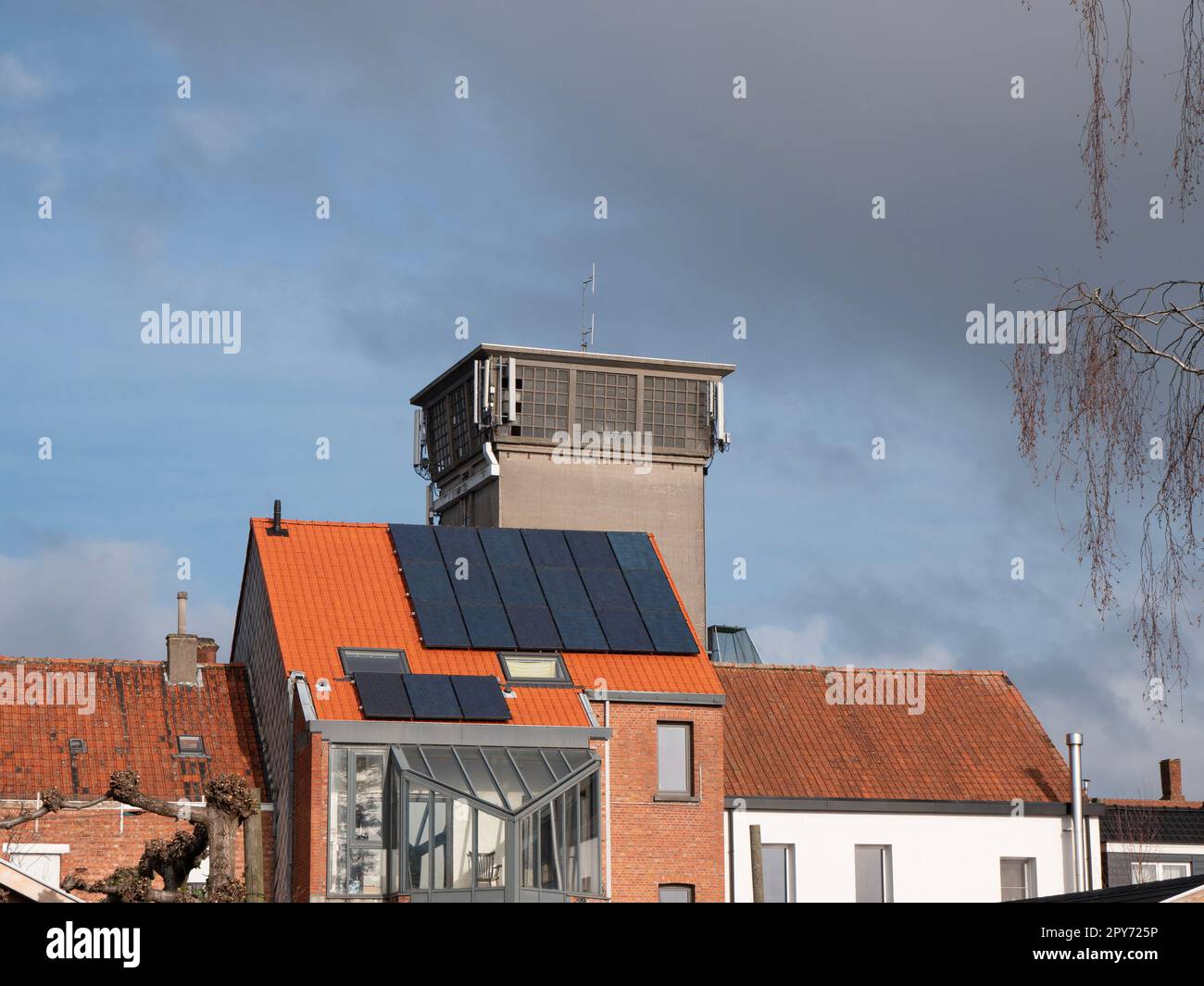 Ein Haus mit orangefarbenen Dachziegeln und neuen Solarpaneelen Stockfoto