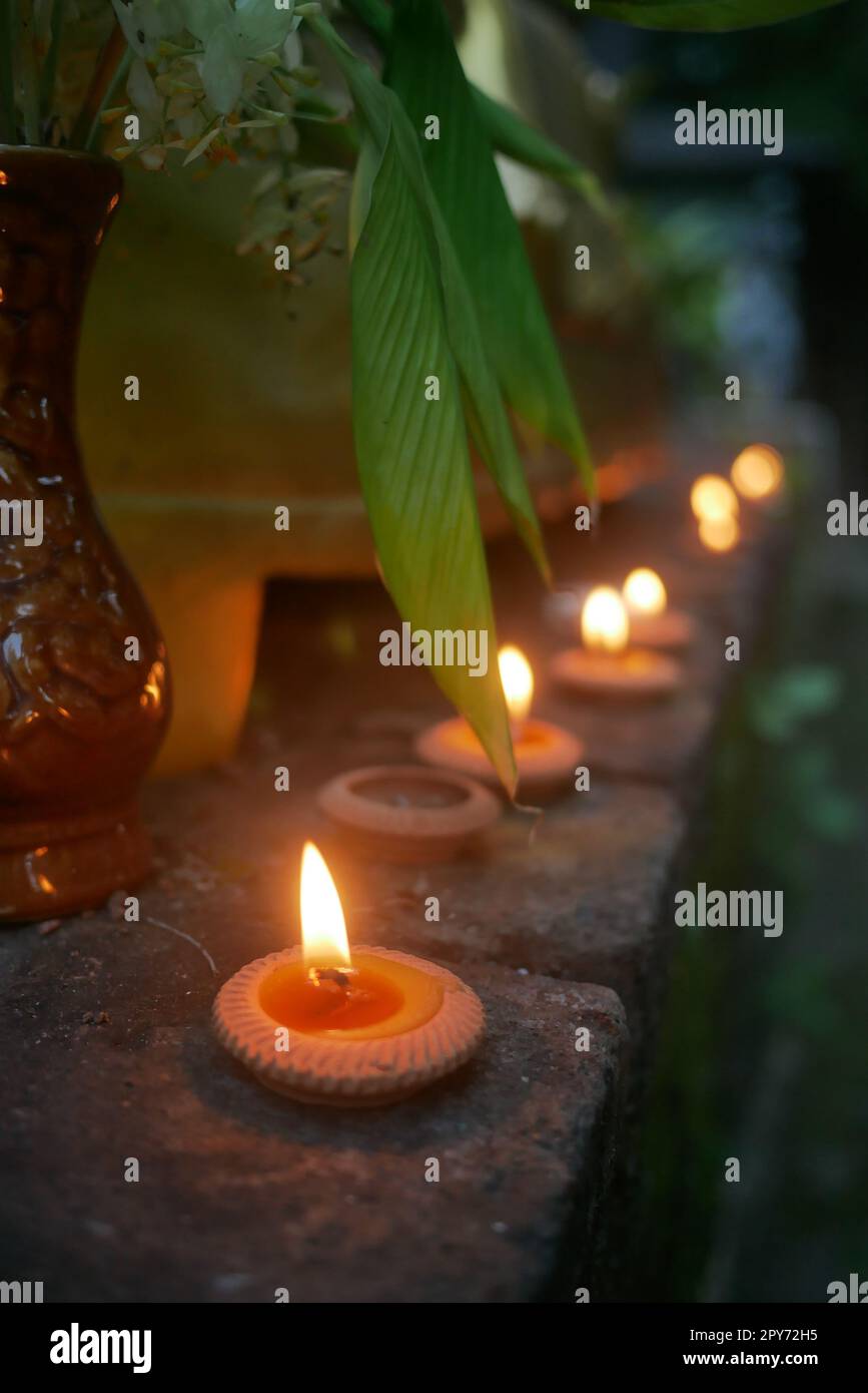 Nahaufnahme beleuchteter Teelichterkerzen vor dem buddhistischen Tempel in Thailand Stockfoto