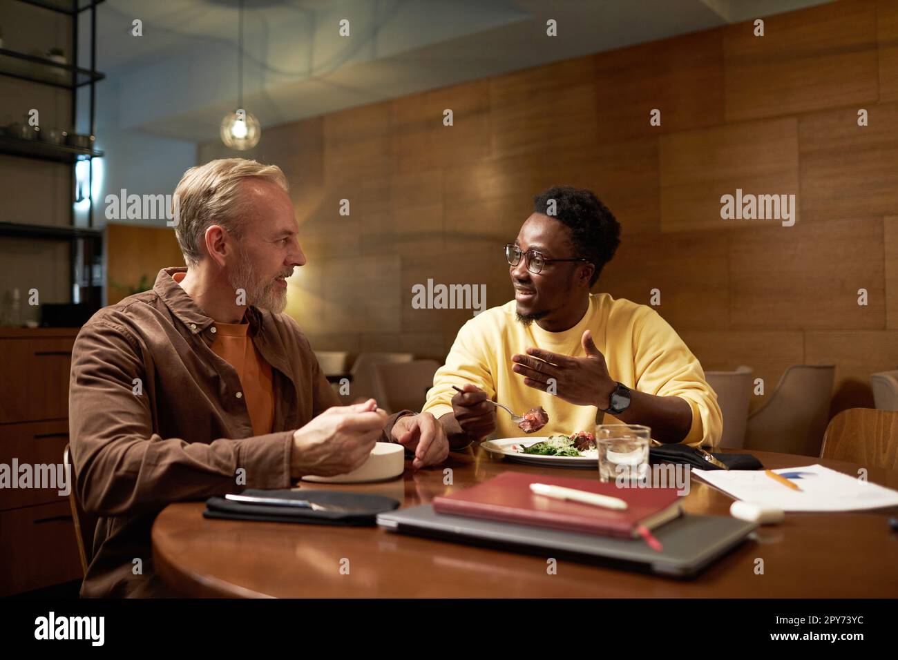 Zwei Kollegen besprechen Pläne während eines Meetings während des Geschäftsessens im Restaurant Stockfoto