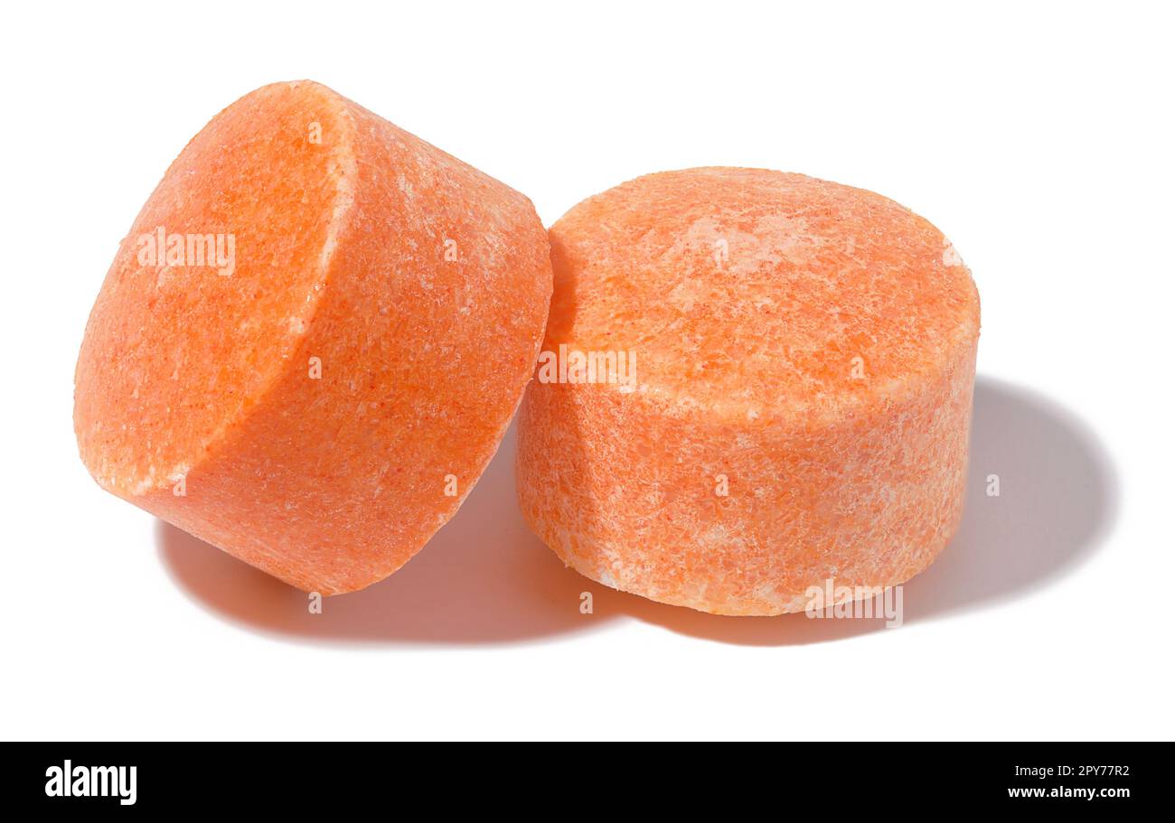 Zwei runde orangefarbene Tabletten auf einem weißen isolierten Hintergrund, Vitamin C Stockfoto