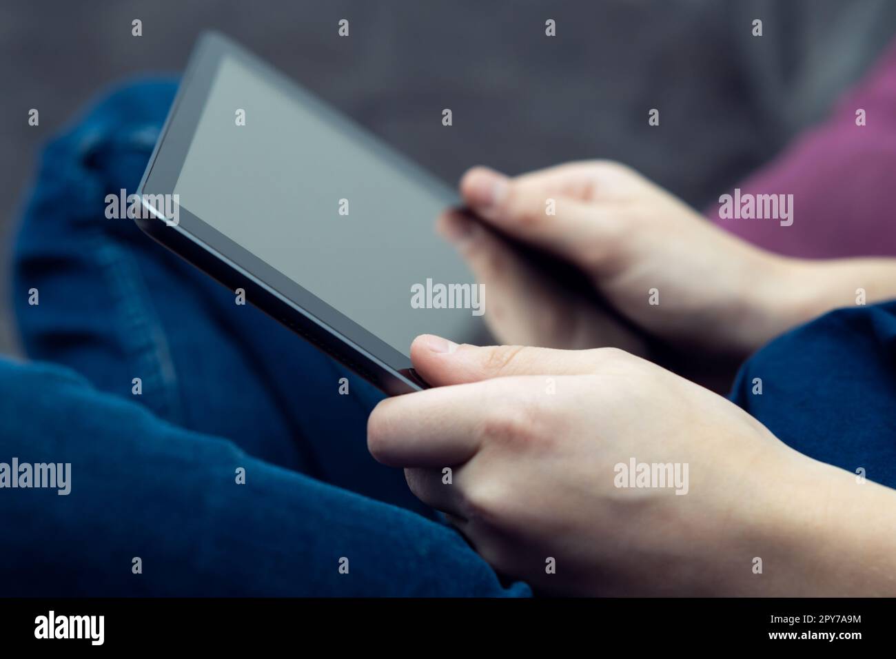 Verkürzte männliche Hände verwenden ein digitales Tablet mit schwarzem Bildschirm. Online-Videospiele spielen als Freizeitaktivität. Mobile Anwendung Stockfoto