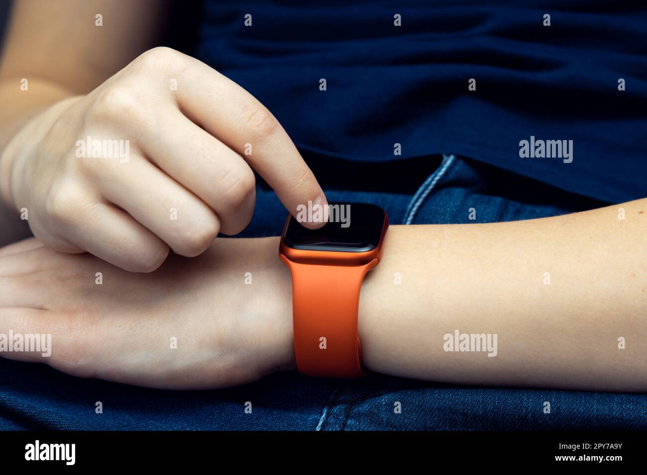 Nicht wiedererkennbare männliche Hand mit roter Bluetooth-Smartwatch, elektronischer Gadget-Technologie. Herzfrequenz, Zeit und Anrufnachricht Stockfoto