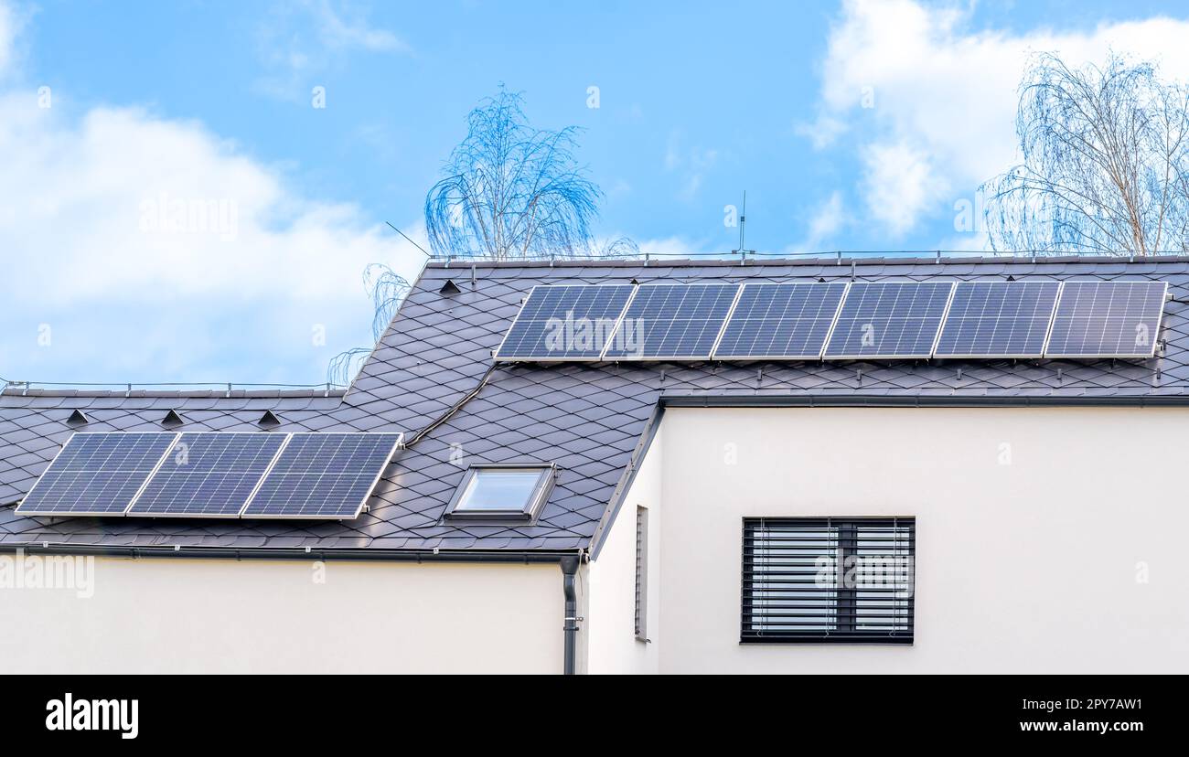 Solarpaneele zur Erzeugung von Strom aus der Sonne auf dem Dach eines Familienhauses Stockfoto