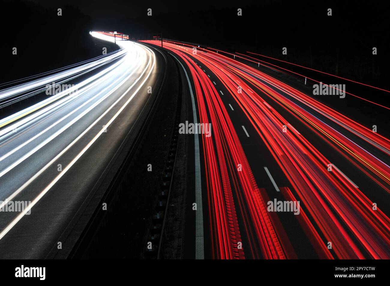 In der Nacht, Reisen und gute Verkehrsmittel auf der Autobahn - die Autobahn fährt normalerweise ohne Staus. Heizleuchten und Schlussleuchten in Rot und Weiß. Stockfoto