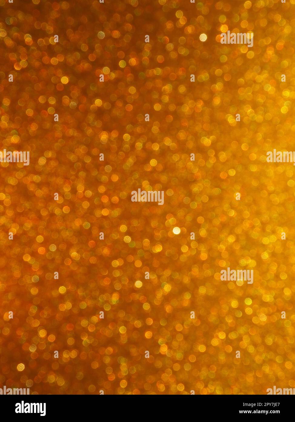 Bokeh-Licht aus Gold glitzert. Goldener, glitzernder Hintergrund. Glitzerndes Geschenkpapier mit Pailletten und Glitzern. Festliches goldenes Bokeh und Glitzer. Wunderschöner Hintergrund. Stockfoto
