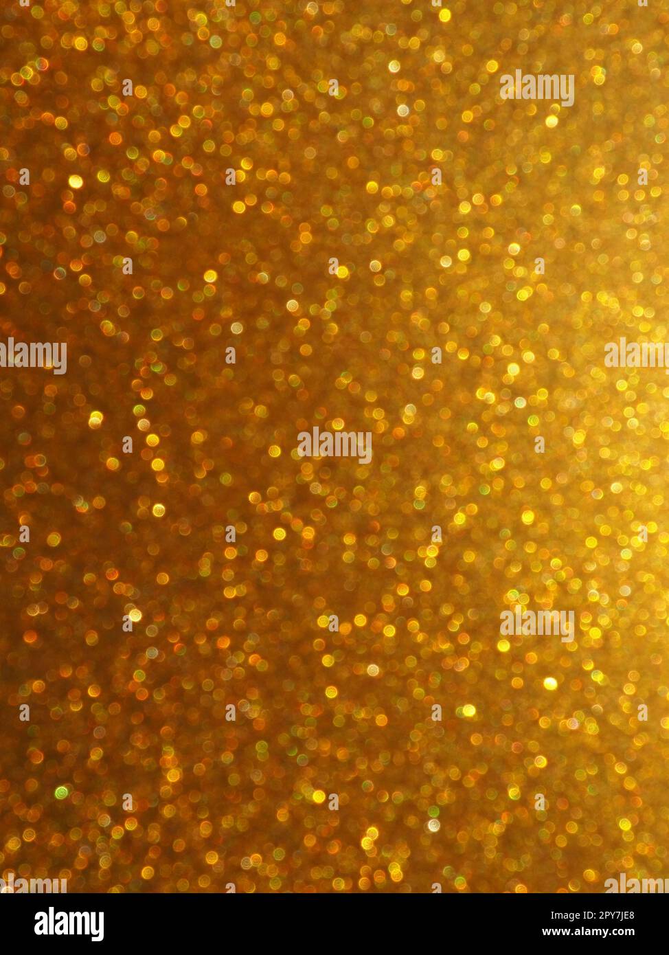 Bokeh-Licht aus Gold glitzert. Goldener, glitzernder Hintergrund. Glitzerndes Geschenkpapier mit Pailletten und Glitzern. Festliches goldenes Bokeh und Glitzer. Wunderschöner Hintergrund. Stockfoto