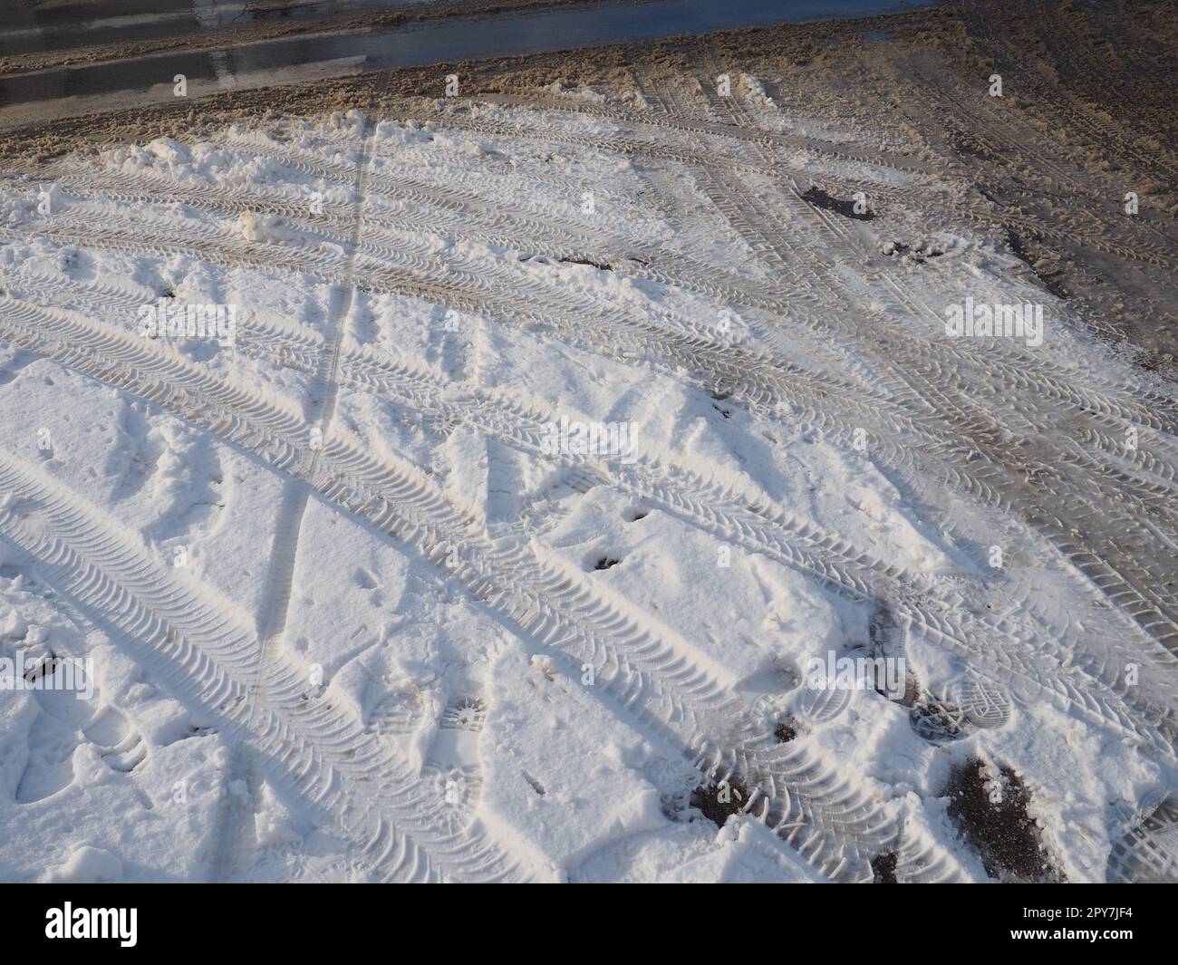 Eine Gabel oder ein Schild aus einem Kreisverkehr. Schneeverwehungen am Straßenrand. Schlechtes Wetter. Schnee auf Asphalt. Schwierige Fahr- und Verkehrsbedingungen. Winterschlamm auf der Straße. Bremsweg eines Autos Stockfoto