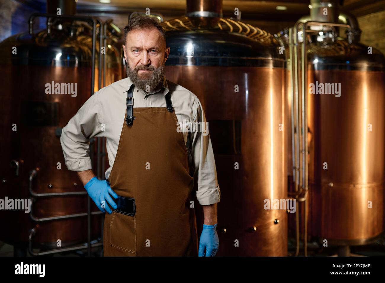 Porträt eines Brauereibesitzers, der Schürze mit gekreuzten Armen trägt Stockfoto