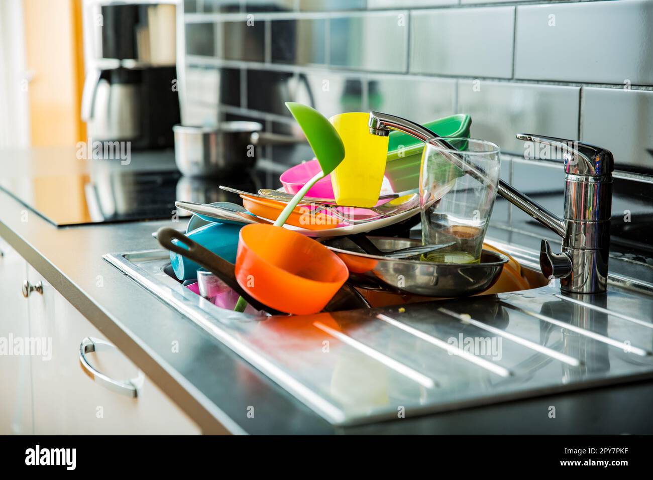 Das Waschbecken war voller schmutzigem Geschirr. Dunkle Arbeitsfläche in moderner Küche. Hausarbeit-Konzept Stockfoto
