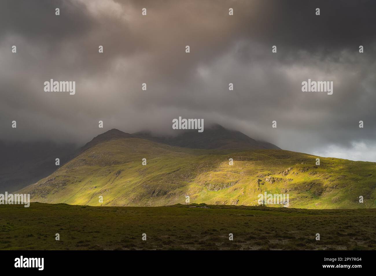 Doolough Valley, Glenummera und Glencullin Gebirgszüge beleuchtet von Sonnenlicht, Irland Stockfoto