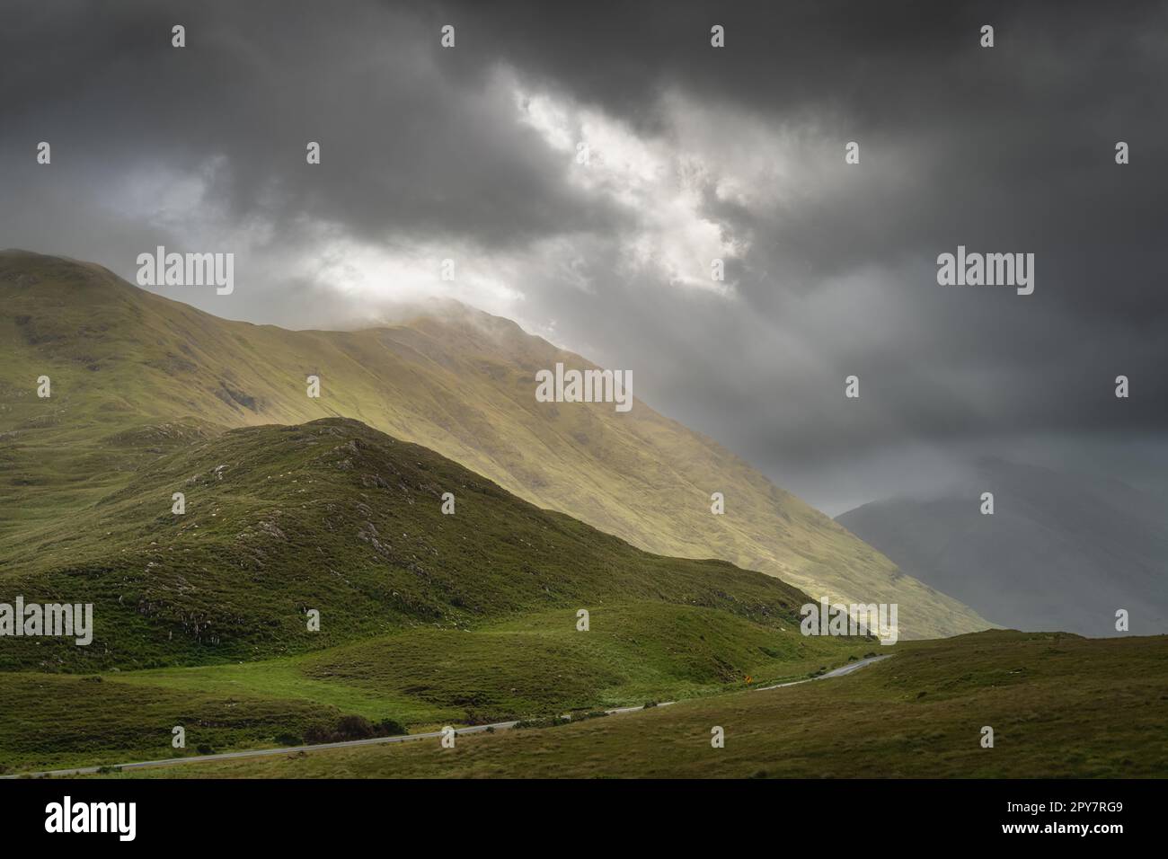 Doolough Valley, Glenummera und Glencullin Gebirgszüge beleuchtet von Sonnenlicht, Irland Stockfoto
