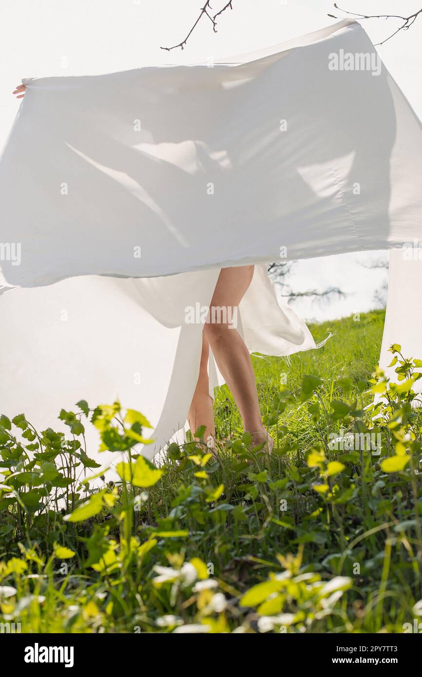 Lady posiert mit weißem Tuch auf einer Wiese, malerische Fotografie Stockfoto