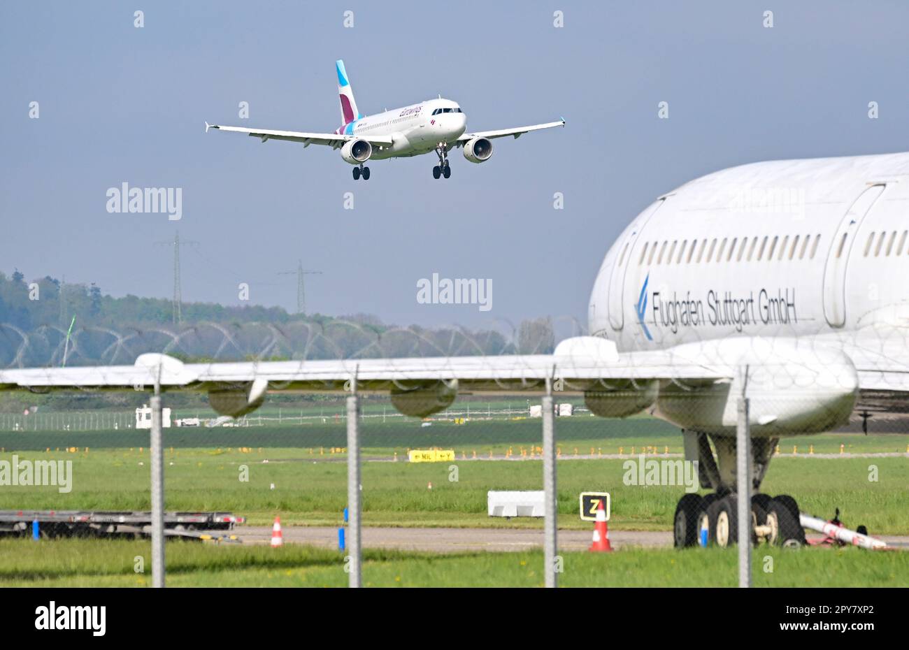 Stuttgart, Deutschland. 03. Mai 2023. Auf dem Flughafen Stuttgart, der Hauptstadt des Bundesstaates Baden-Württemberg, landet ein Passagierflugzeug. Im Vordergrund befindet sich ein Flugzeug des Flughafens, das für Rettungsübungen verwendet wird. Der Flughafen kündigt seine Geschäftszahlen für das vergangene Jahr auf einer Pressekonferenz an. Kredit: Bernd Weißbrod/dpa/Alamy Live News Stockfoto