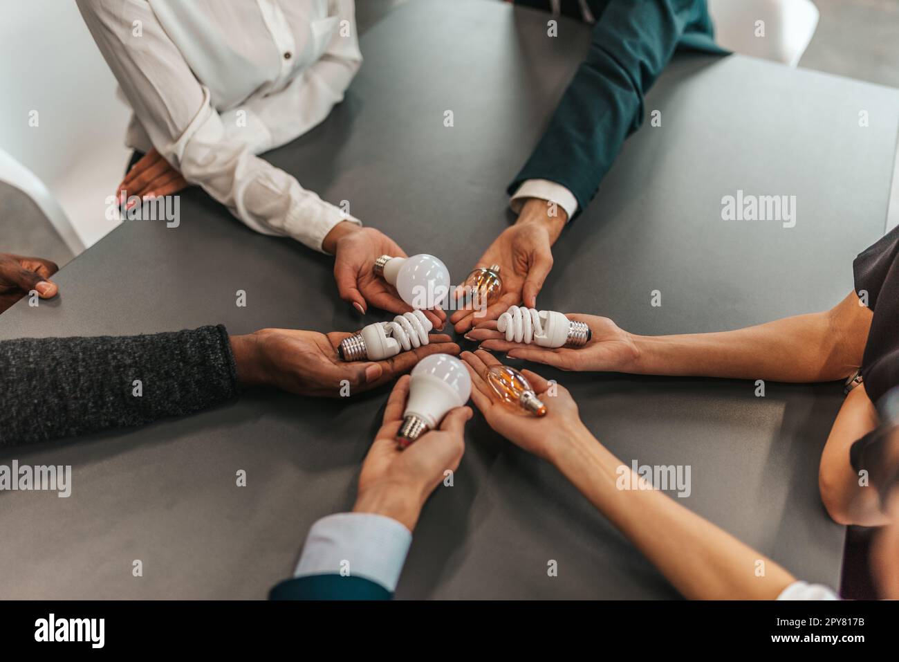 Teamwork und Brainstorming-Konzept mit Geschäftsleuten, die eine Idee mit einer Lampe teilen Stockfoto