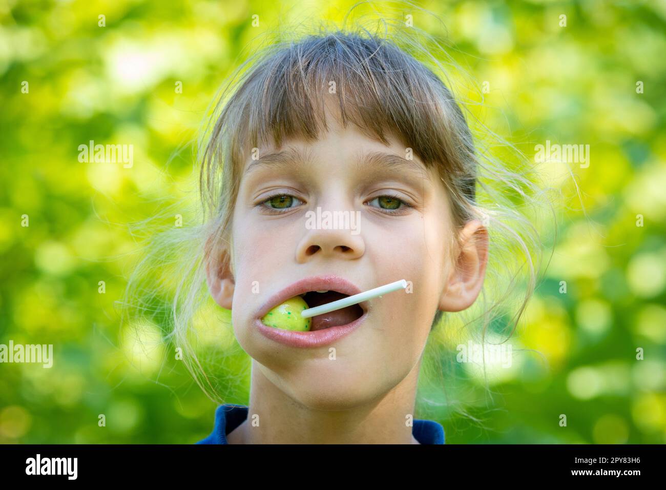 Das Mädchen hat einen großen runden Lutscher im Mund, Nahaufnahme Porträt Stockfoto