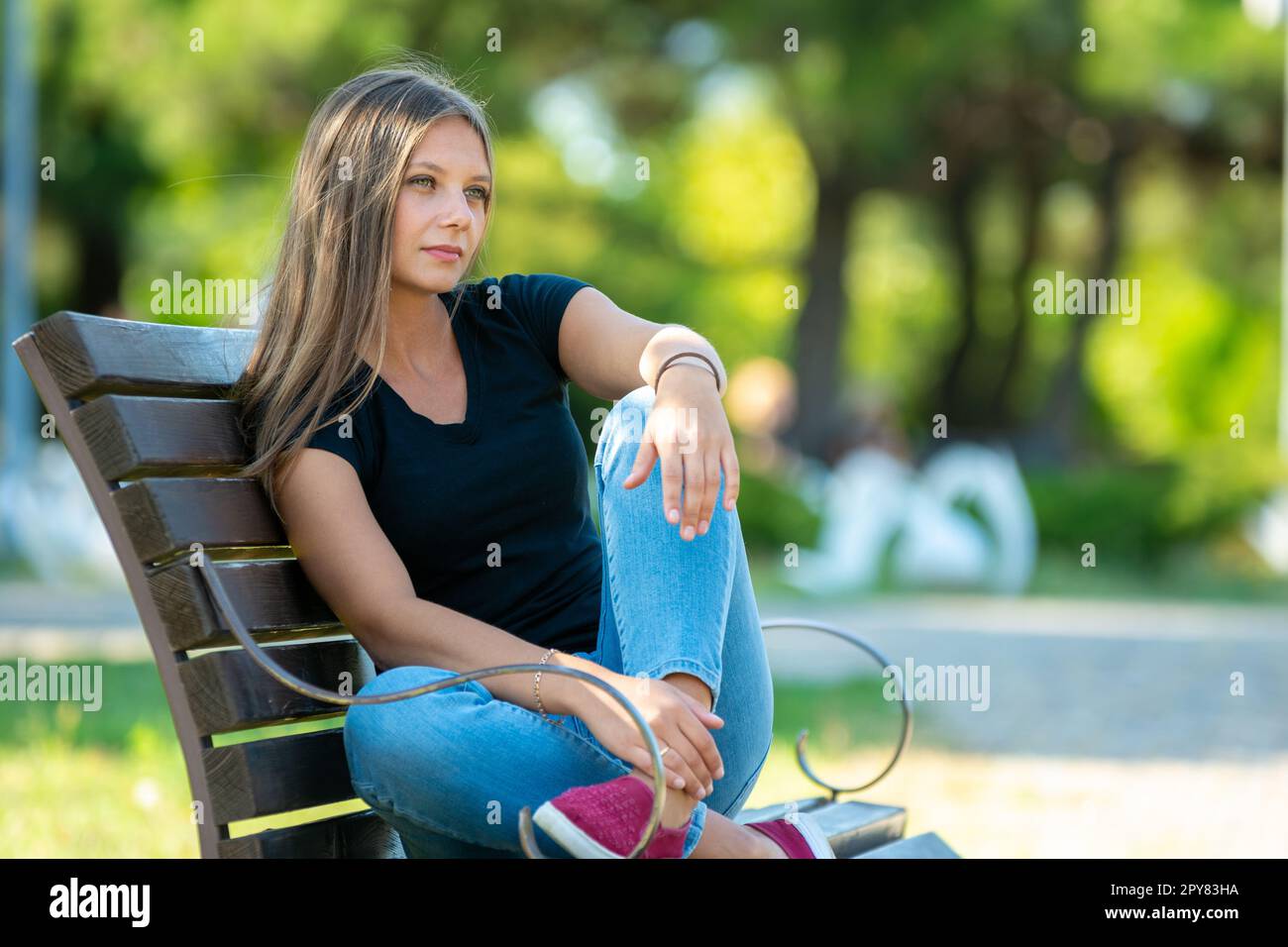 Mädchen sitzt auf einer Bank im Park, Nahaufnahme Stockfoto