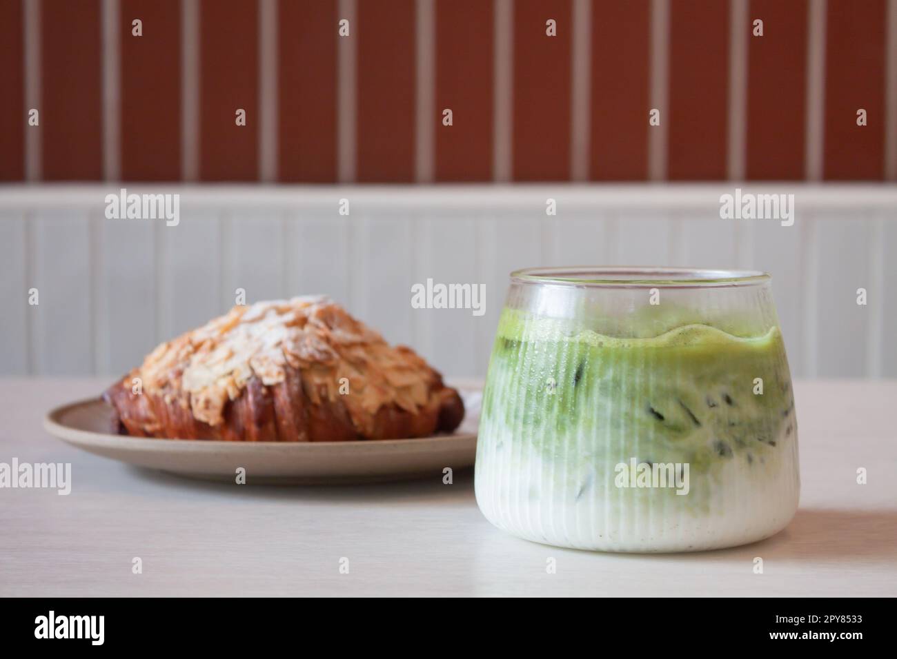 Grüner Eismatcha-Tee serviert mit Croissant Stockfoto