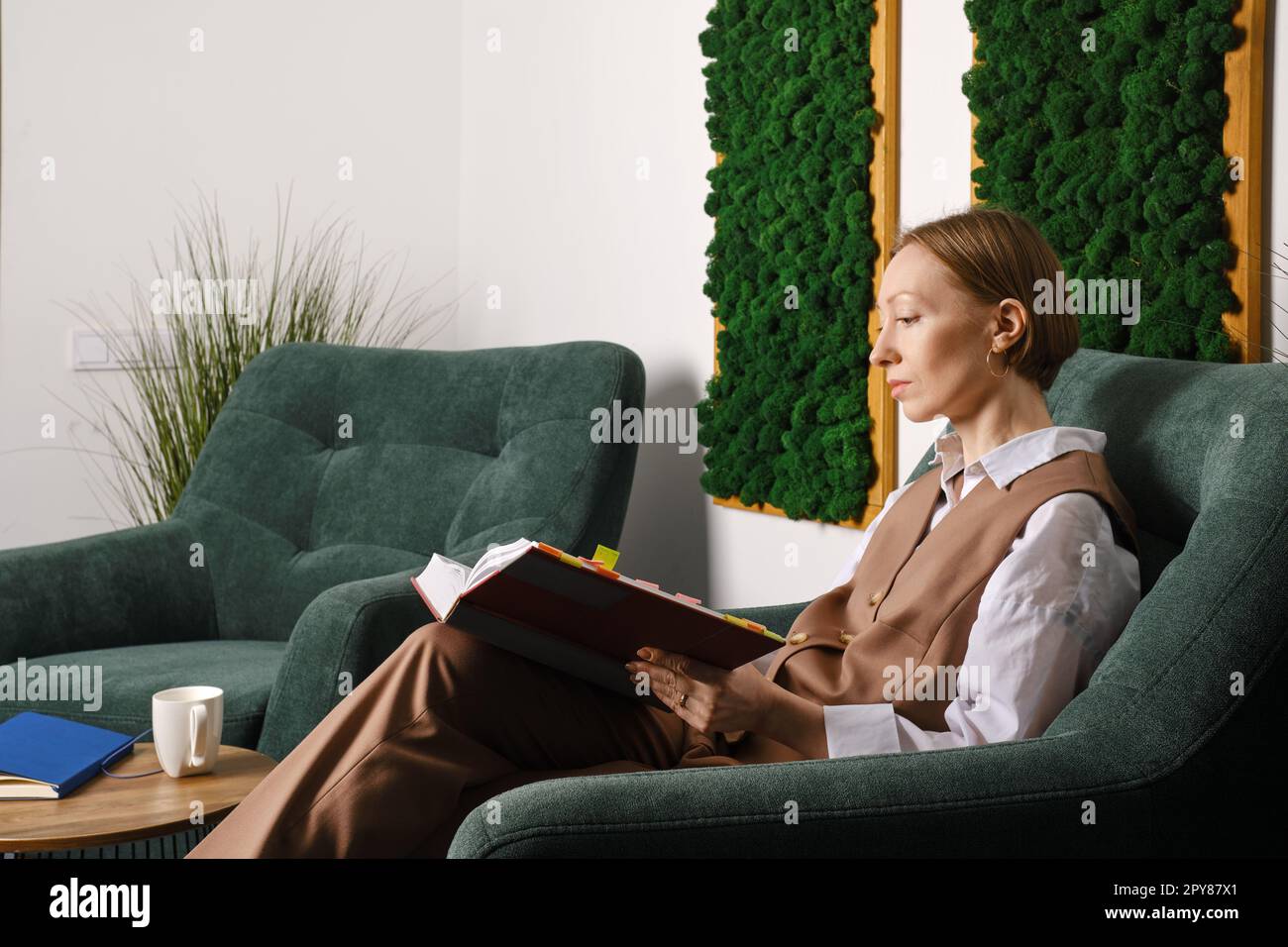 Mittelalterliche weibliche Schicht, die in der Bürotoilette sitzt Stockfoto