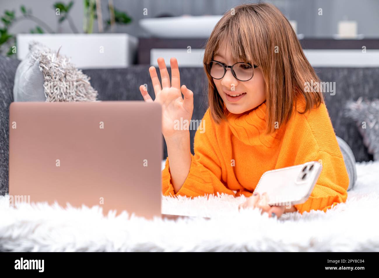 Das Kind kommuniziert zu Hause online mit Hilfe moderner Technologien Stockfoto