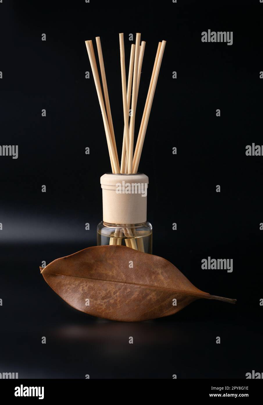 Flasche raumduft-diffusor mit drei sticks auf einem holztablett