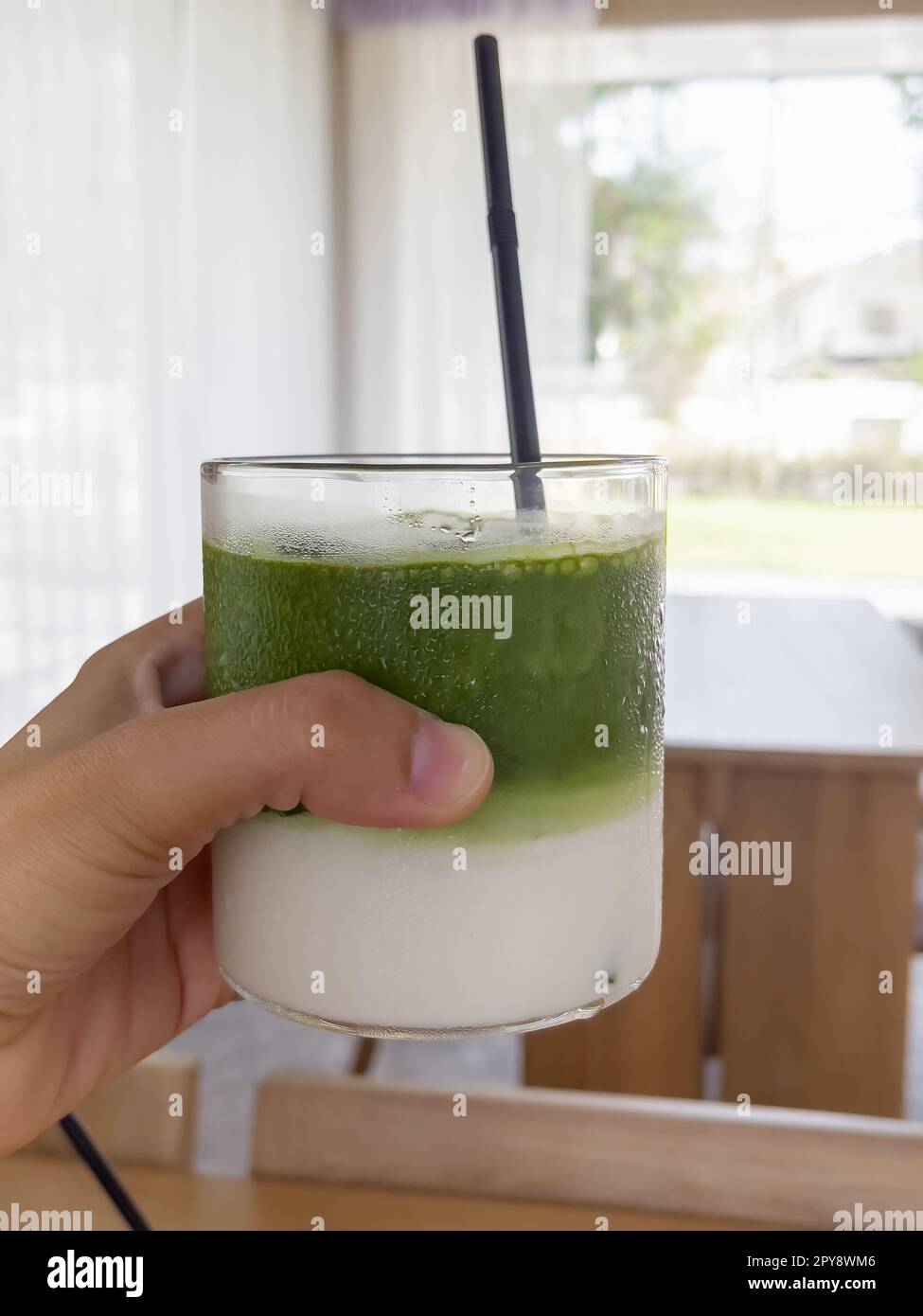 Handgehaltener Eistee mit Matcha-Grün Stockfoto