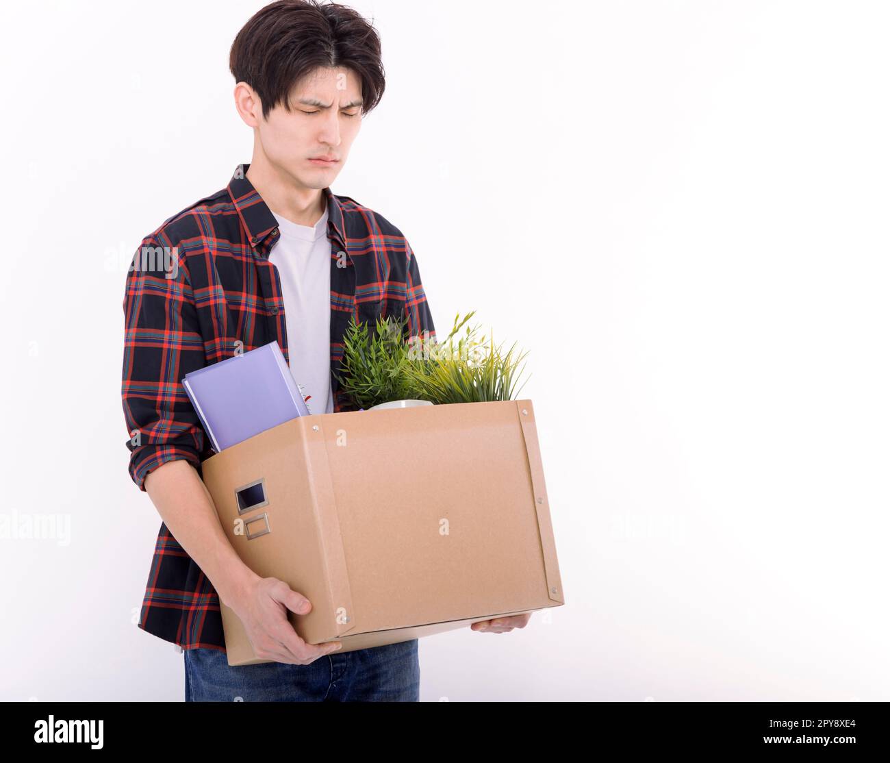 Ein junger Geschäftsmann, der Zeug hält, tritt deprimiert zurück Stockfoto
