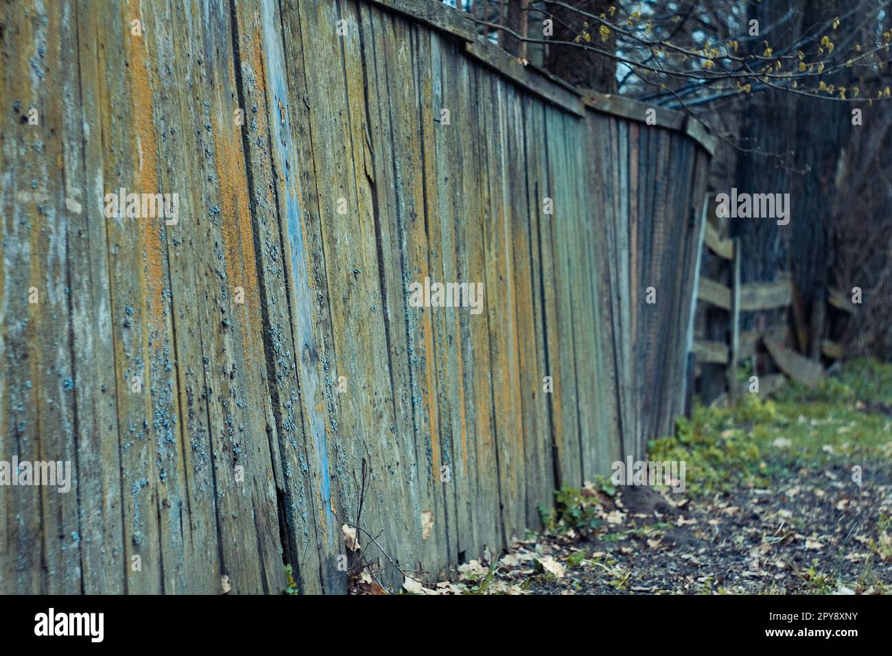 Nahaufnahme eines wackeligen Holzzauns mit Herbstlaub auf dem Boden Konzeptfoto Stockfoto