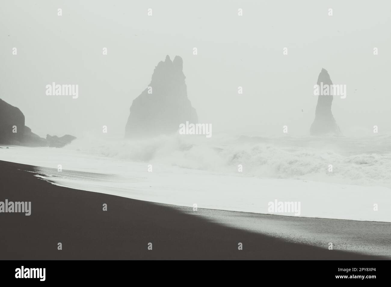 Riesige Wellen gegen Felsen Schwarzweiß-Landschaftsfoto Stockfoto