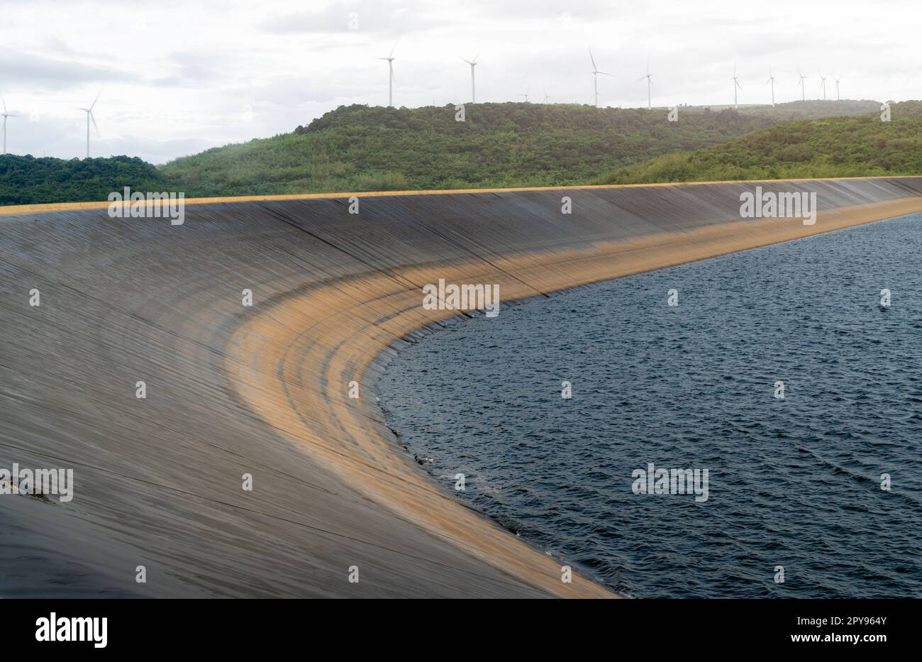 Mit HDPE-Kunststoff ausgekleidete Wasserreservoirs und Landschaft des Windparks für Kraftwerke. Technisches Material aus Polyethylen hoher Dichte. Windkraft. Nachhaltige, erneuerbare Energien. Windmühlen-Farm. Stockfoto