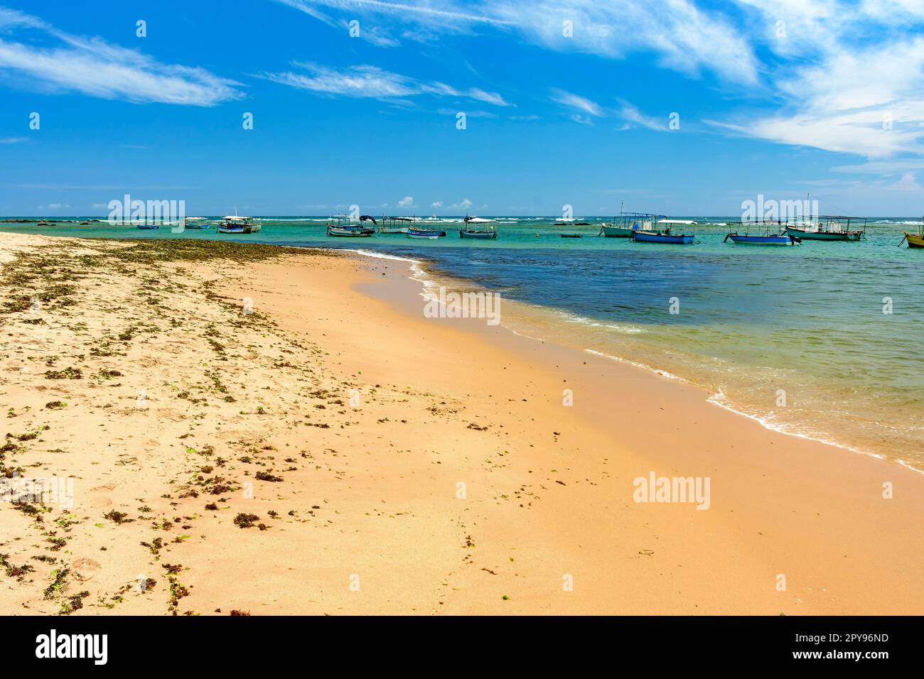 Boote auf dem transparenten Wasser von Itapua Beach in der Stadt Salvador in Bahia an einem sonnigen Tag, Brasilien Stockfoto