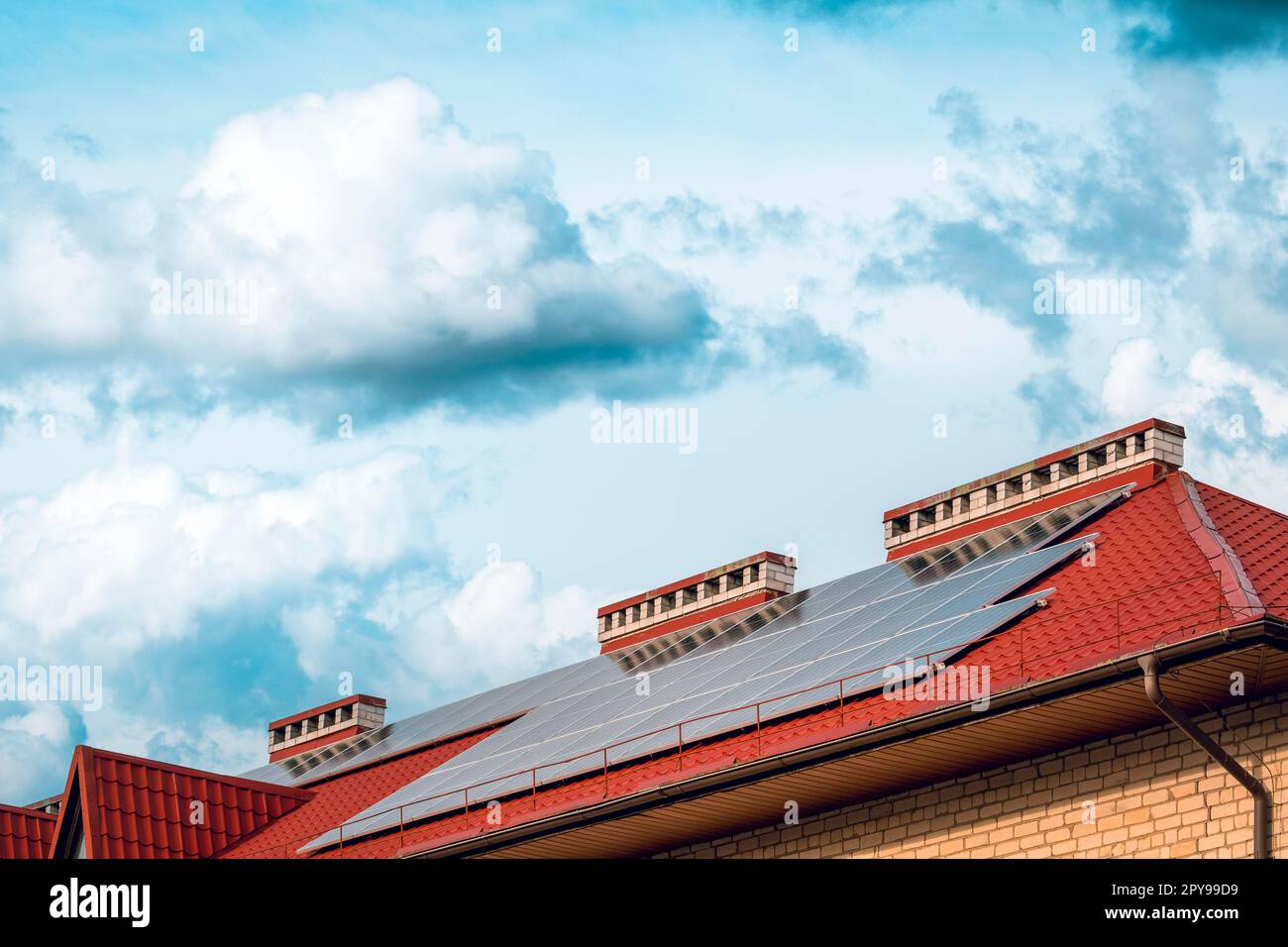 Photovoltaik- oder Solarpaneele in einem Haus mit rotem Dach Stockfoto