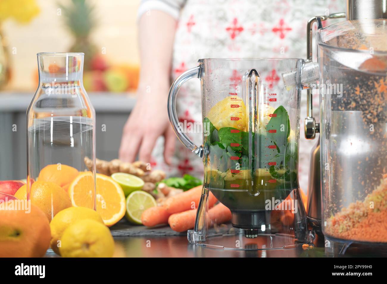 Drücken Sie Karottensaft mit Entsafter gesunde Zitrusfrüchte im Hintergrund. Einnahme Vitamine Entgiftung, gesunde Ernährung und Lebenskonzept. Stockfoto