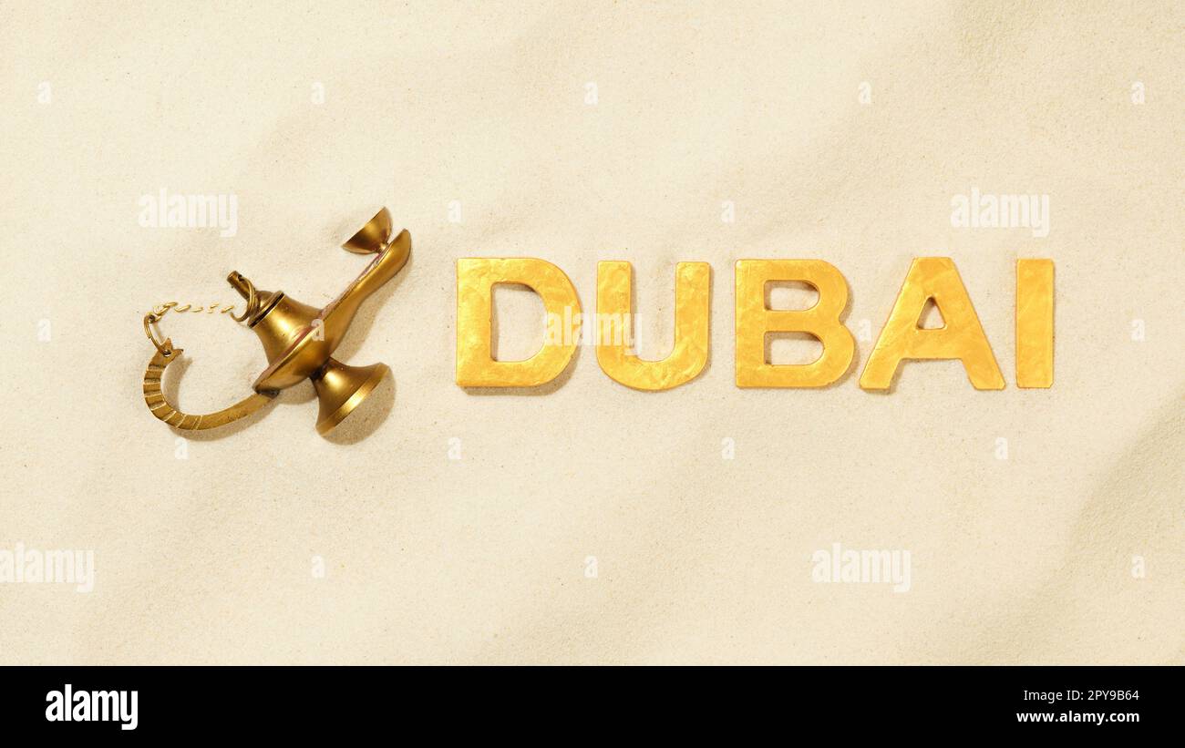 Dubai - Name der Stadt mit einer alten magischen Öllampe im Sand Stockfoto
