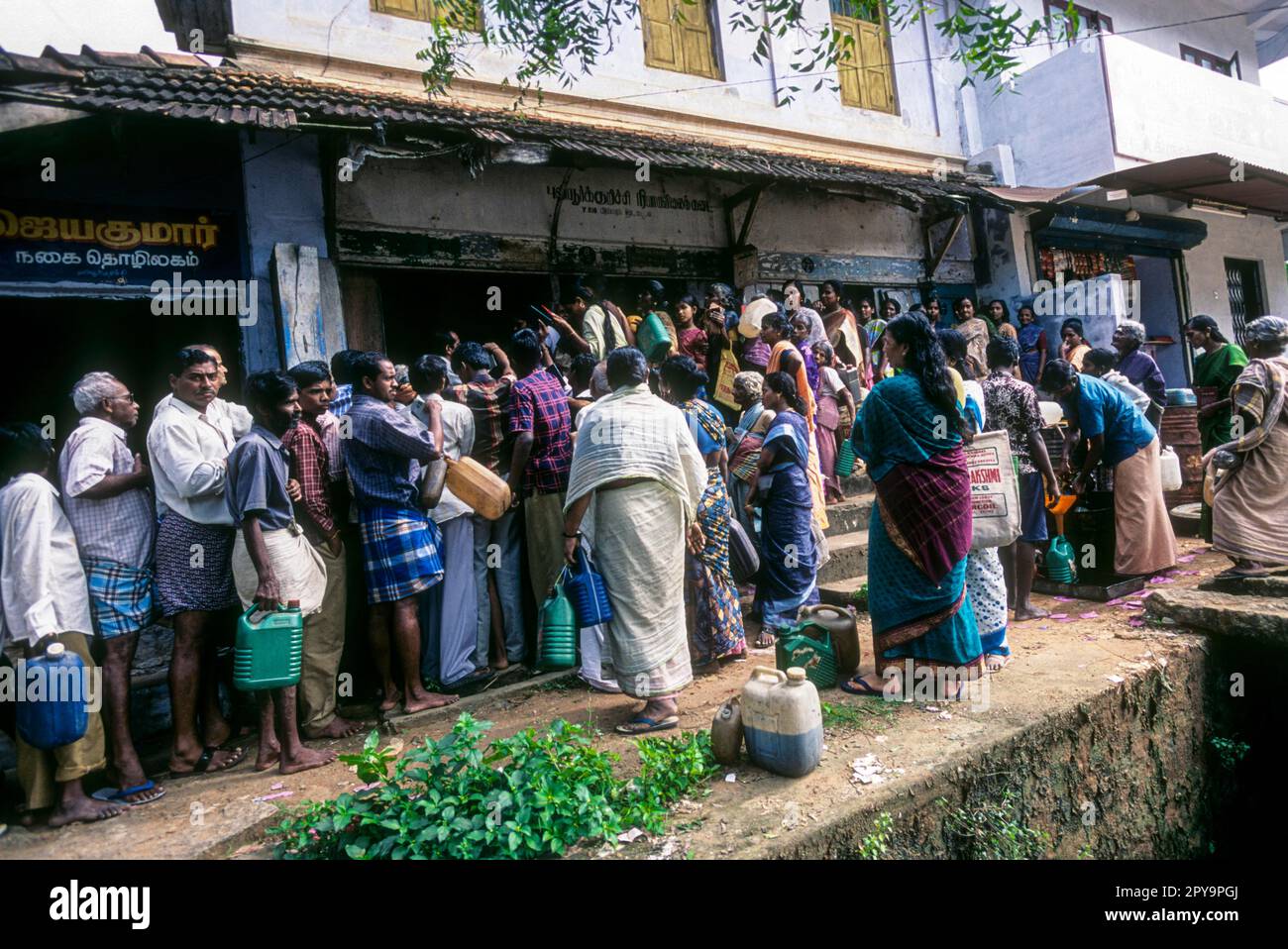 Leute versammeln sich vor dem Ration Shop, Südindien, Indien, Asien Stockfoto