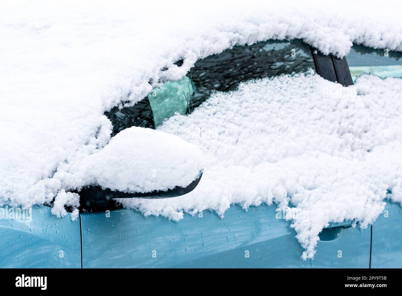 Nahaufnahme eines schneebedeckten Autoflügelspiegels Stockfoto