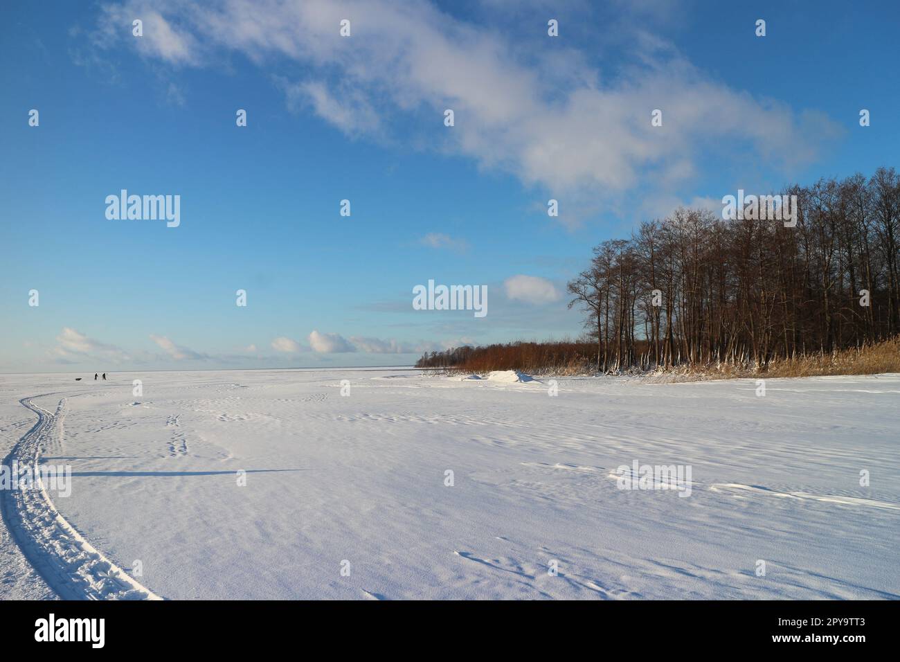 Winter gefrorener See, Schlittenspur, Silhouetten von Menschen Stockfoto