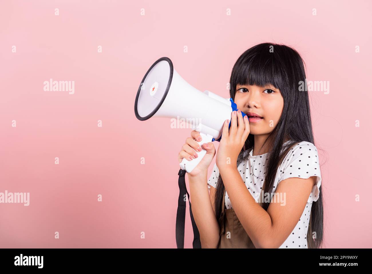 Asiatisches kleines Kind 10 Jahre alt schreiend durch Megaphon Stockfoto