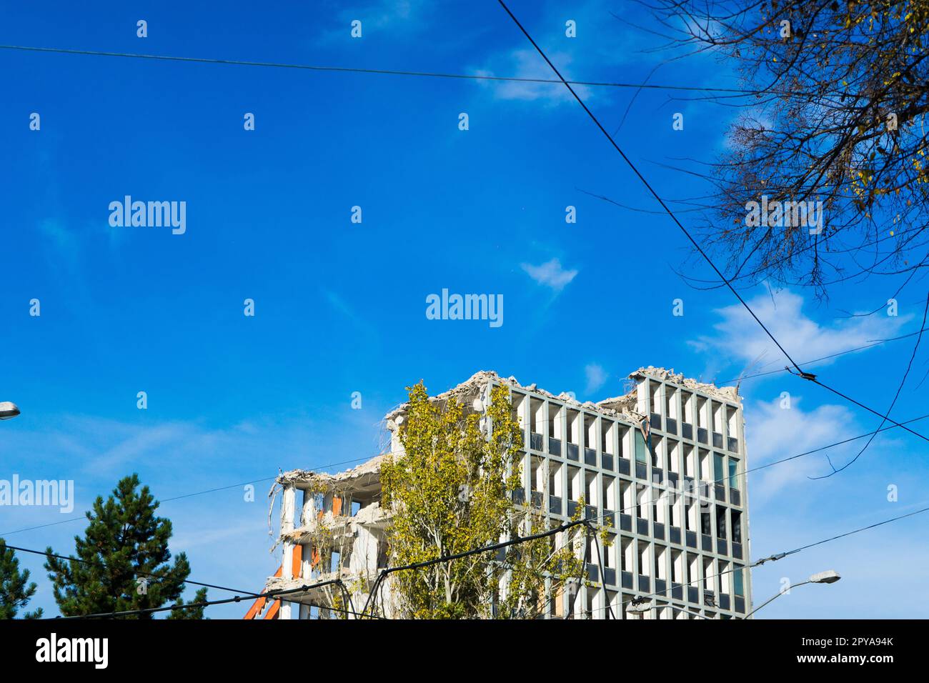 Hintergrund des Abbruchprozesses von Gebäuden. Ein Bagger zerbricht das alte Haus. Stockfoto