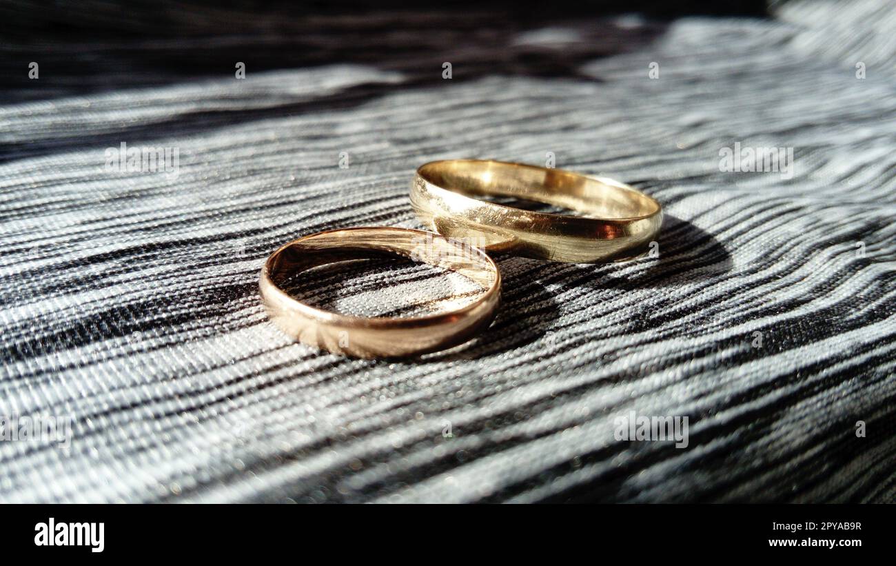 Zwei goldene Ringe auf einem grauen Hintergrund für die Zeremonie Stockfoto